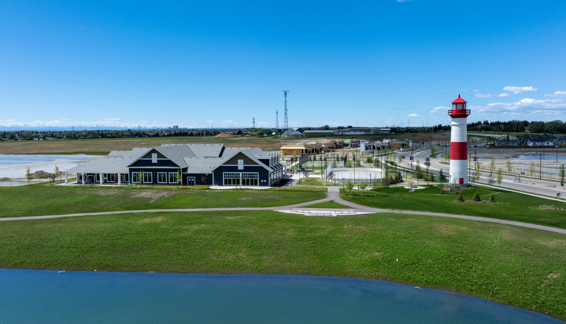 Aerial view of the clubhouse, lake and lighthouse with mountains